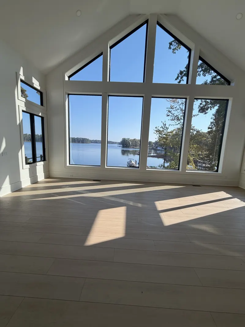 Sunlit great room with a two-story gable window wall overlooking a boat dock on Lake Murray