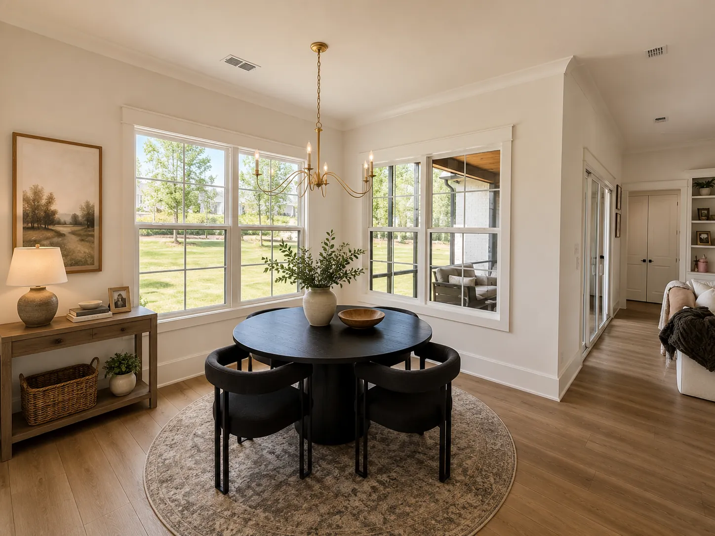 Breakfast room with round table, brass chandelier and corner windows
